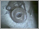 1981 Ford Bronco - A close-up view of a flywheel, likely a vehicle part, resting on a concrete surface.