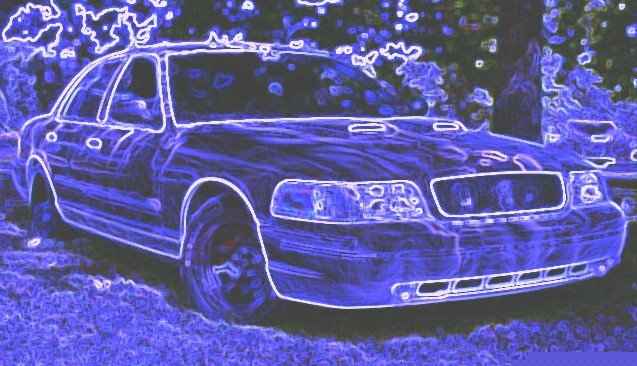 Front 3/4 view of a 2001 Ford Crown Victoria parked outside. Another vehicle is visible behind it