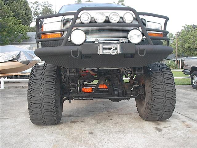 Lifted truck front end with large tires, winch, and brush guard