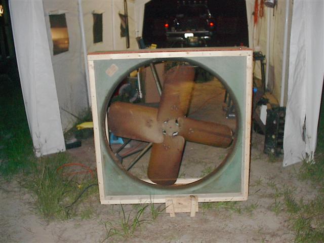 Large industrial fan with wooden frame and four brown blades