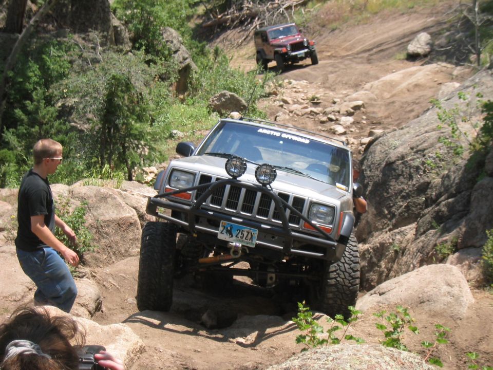 1997 Jeep Cherokee navigating a rocky trail with another Jeep in the background