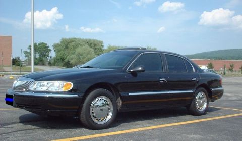 1997 Ford Crown Victoria - This 1997 Lincoln Continental sedan is captured in a three-quarter front view, parked in an outdoor lot.