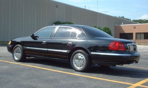 1997 Ford Crown Victoria - A black Lincoln Continental is parked in a lot with a building in the background.