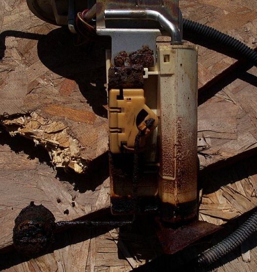 Used fuel pump assembly with visible corrosion and debris