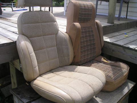1984 Ford Bronco - Two car seats, likely from an older vehicle, are placed on a wooden deck outdoors.