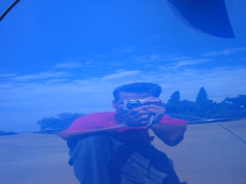 1990 Ford Probe - Reflection of a man taking a photo on a blue car hood, with a logo visible in the lower right corner.