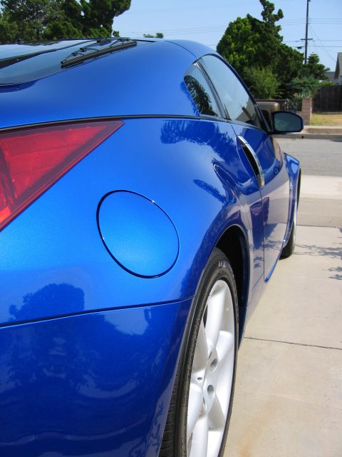 1990 Ford Probe - Close-up of a blue sports car's rear quarter panel, showing the taillight and fuel cap.