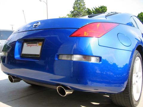 1990 Ford Probe - Rear view of a blue Nissan 350Z, showing its distinctive taillights and dual exhaust system.