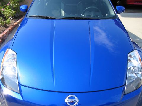 1990 Ford Probe - The front of a blue Nissan 350Z is shown, with the hood and headlights clearly visible.