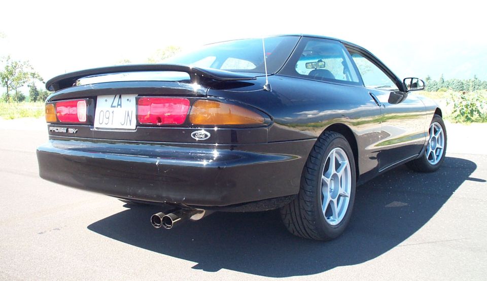 Black Ford Probe coupe rear view with spoiler and dual exhaust tips