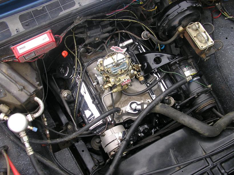 Engine bay with V8 engine, carburetor, MSD ignition box, and alternator. Visible text: MSD, Edelbrock, SUPERMOTORS.NET