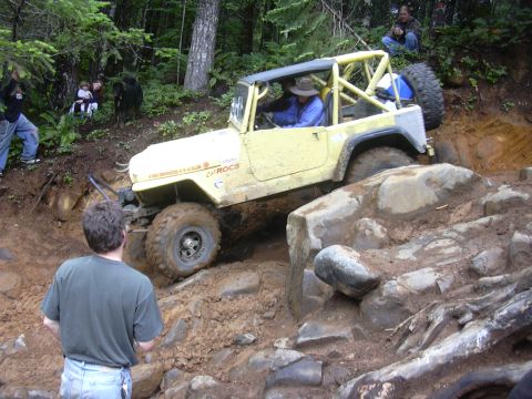 1991 Ford Bronco - This off-road vehicle navigates a challenging rocky terrain with onlookers observing the ascent.