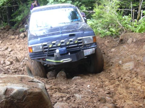 1991 Ford Bronco - This SUV is tackling a challenging off-road course with steep inclines and large rocks.