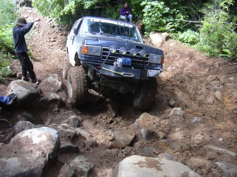 1991 Ford Bronco - This 1991 Ford Bronco tackles a challenging off-road course, demonstrating its capability on rough terrain.