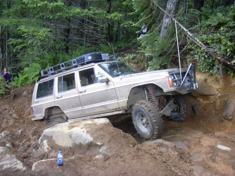 1991 Ford Bronco - This modified Jeep Cherokee XJ is tackling a challenging off-road course with steep inclines and rocky obstacles.