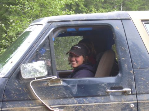 1991 Ford Bronco - A woman smiles from the driver's seat of a mud-covered SUV.