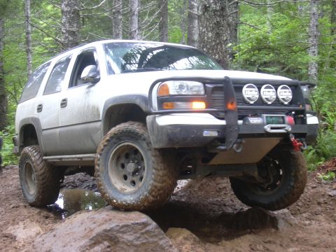 1991 Ford Bronco - This white SUV is equipped for off-road adventures, tackling a challenging trail.