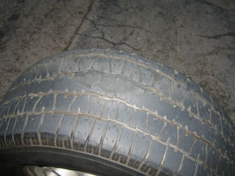 1985 Ford Mustang - Close-up of a tire showing significant wear and damage.