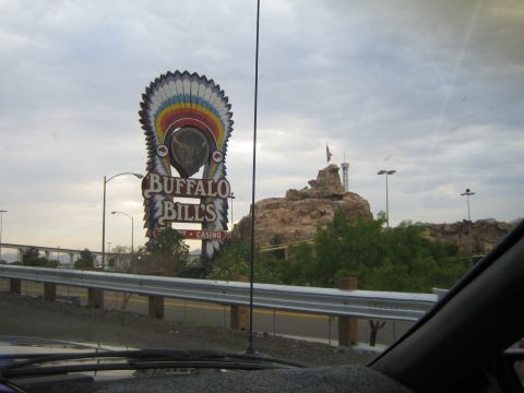 1985 Ford Mustang - A large sign for Buffalo Bill's Casino stands against a cloudy sky, with a rocky landscape behind it.