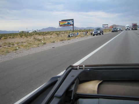 1985 Ford Mustang - A highway scene with multiple vehicles, including one pulled over on the shoulder.