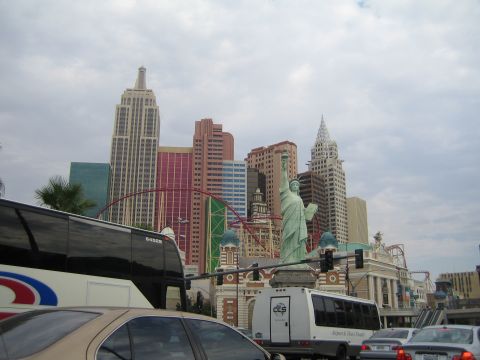 1985 Ford Mustang - Las Vegas skyline at New York-New York Hotel and Casino, with traffic on the street.