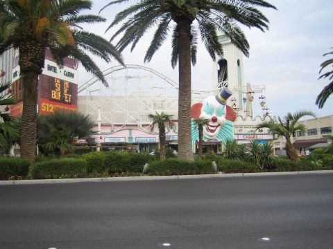 1985 Ford Mustang - A view of a Las Vegas hotel and casino complex a roller coaster and a giant clown face.