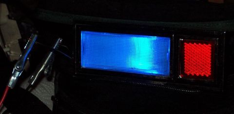 1985 Ford LTD Crown Victoria - Close-up of a vehicle's interior light and reflector, with alligator clips connected.