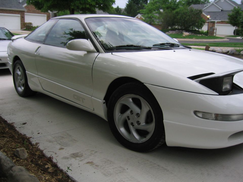 White coupe with pop-up headlights and 'GT' badging on the side