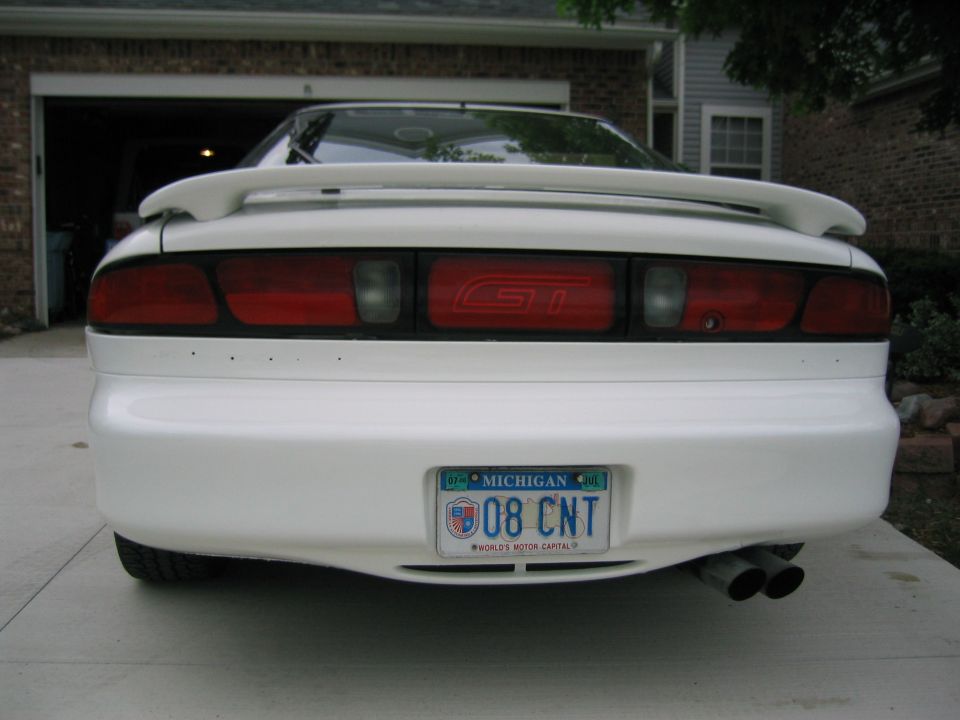 White sports car rear view with GT badge on taillight assembly and Michigan license plate 08 CNT