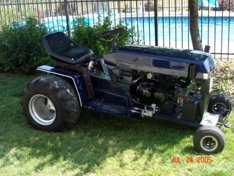 1979 Ford Bronco - This custom riding mower features large rear tires and an exposed engine, set against a backyard pool backdrop.