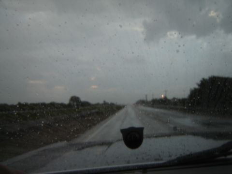 1988 Ford LTD Crown Victoria - Driving through a rainstorm on a wet highway, with raindrops visible on the windshield.