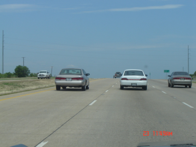 Car on highway, seen from behind. Another car is in the right lane