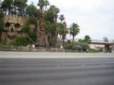 1985 Ford Mustang - A pirate ship attraction is set against a backdrop of a skull-shaped rock formation and palm trees.