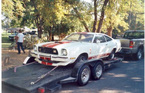 1978 Ford Mustang II - 1978 Ford Mustang II Cobra being transported on a trailer with a pickup truck in the background.
