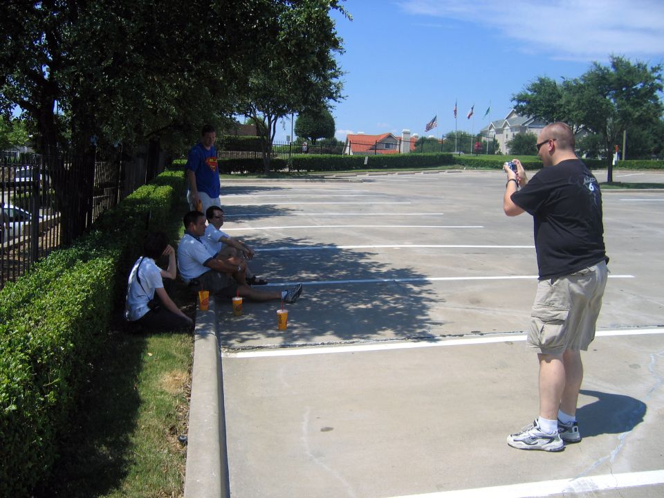 guy taking photo of friends sitting in parking lot