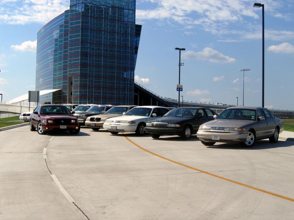 Maroon 1998 Ford Crown Victoria parked in a lot with other sedans