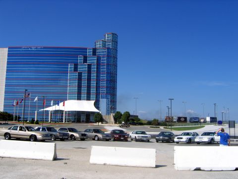 2000 Ford Crown Victoria - A lineup of Ford Crown Victorias from the year 2000 are parked in front of a contemporary building with a distinctive blue glass facade.