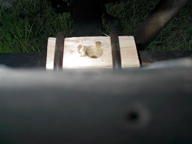 close-up of a wooden block with metal rods attached to a vehicle frame