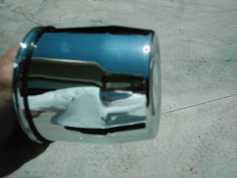 1978 Ford Bronco - A chrome hubcap is shown, reflecting a person in its polished surface.