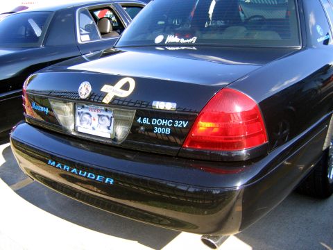 2000 Ford Crown Victoria - The rear of a black Mercury Marauder is shown, with "MARAUDER" text on the bumper and engine specs on the trunk lid.