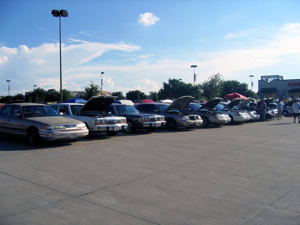 Silver 2000 Ford Crown Victoria in a line of cars with hoods up