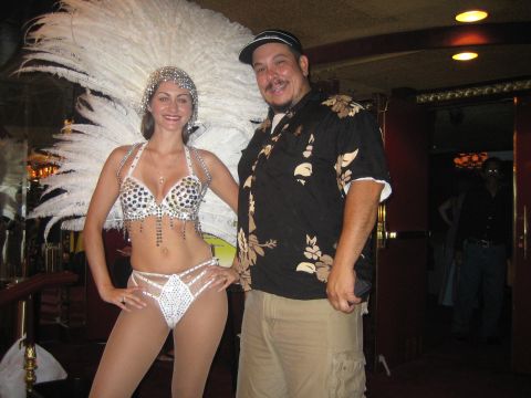 1985 Ford Mustang - A man and a woman in a elaborate costume pose for a photo inside a venue.
