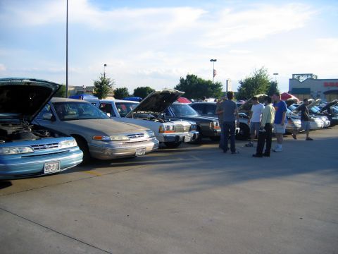 2000 Ford Crown Victoria - Cars gathered at an outdoor event, with several Ford Crown Victorias on display.