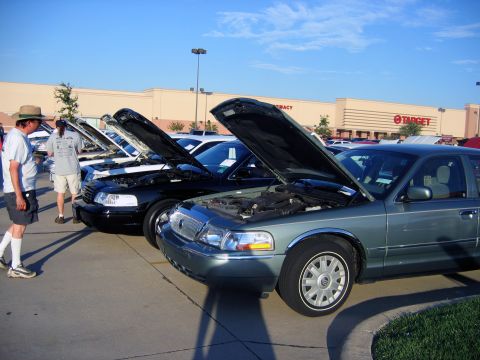 2000 Ford Crown Victoria - Cars on display at a meet, with hoods up showing engines.
