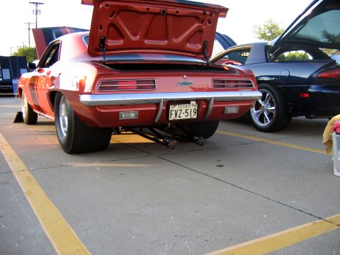 2000 Ford Crown Victoria - A classic Camaro with wide rear tires and a lifted rear end is parked next to another car.