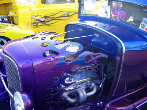 2000 Ford Crown Victoria - Custom hot rod with flame paint and exposed engine, parked next to a yellow truck.