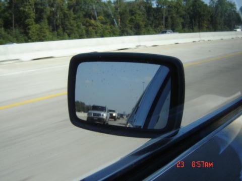 1988 Ford LTD Crown Victoria - Reflection in the side mirror shows two trucks driving on a highway.