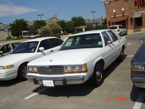 1988 Ford LTD Crown Victoria - White 1988 Ford Crown Victoria sedan parked in a lot on a sunny day.