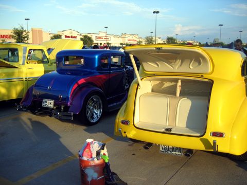 2000 Ford Crown Victoria - Several custom cars are parked in a lot, with a bucket of cleaning supplies in the foreground.