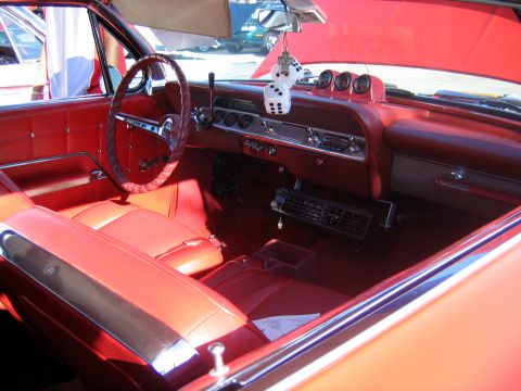 2000 Ford Crown Victoria - The interior of a classic car features red upholstery and a dashboard with multiple gauges and a retro radio.
